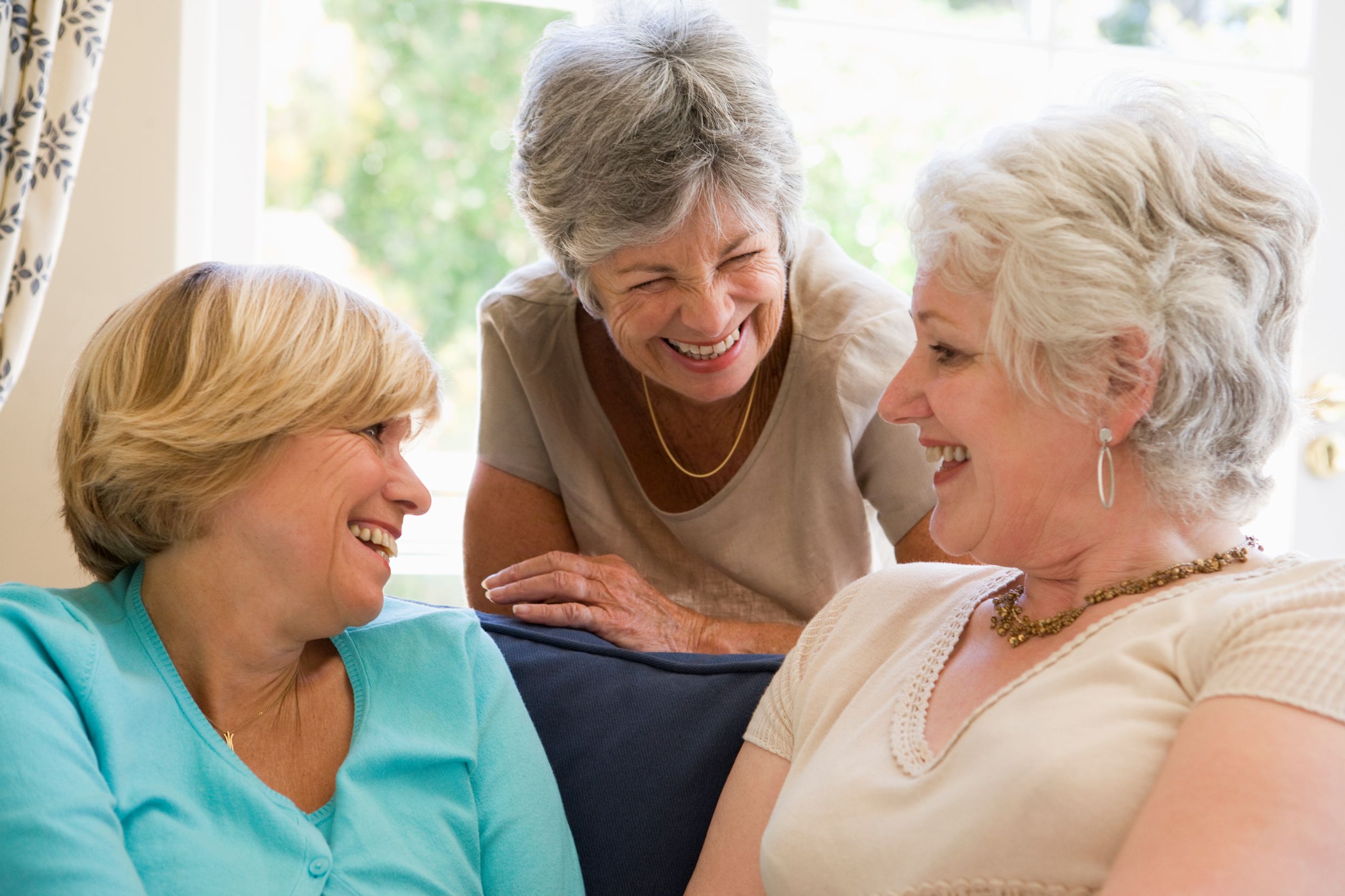 three-women-in-living-room-talking-and-smiling_rKmbdASi